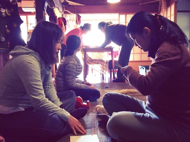 村おこしボランティア【宝島コース】でバナナの繊維を切る作業をするボランティアツアー参加者