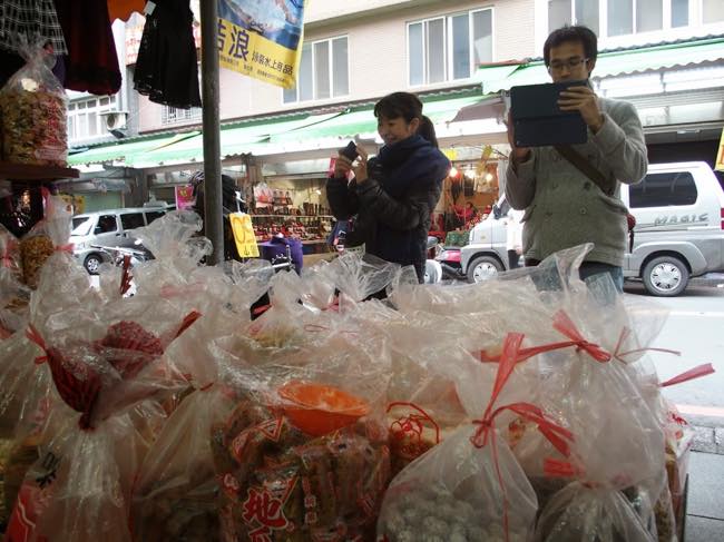 台湾の市場で量り売りされている駄菓子に興奮するボランティアツアー参加者