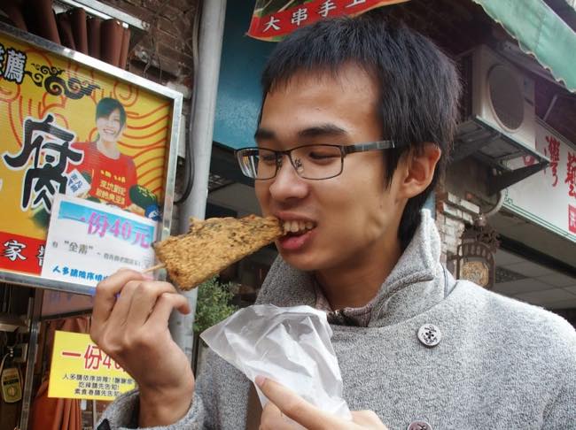 台湾名物の豚の血を固めたお餅に挑戦するボランティアツアー参加者