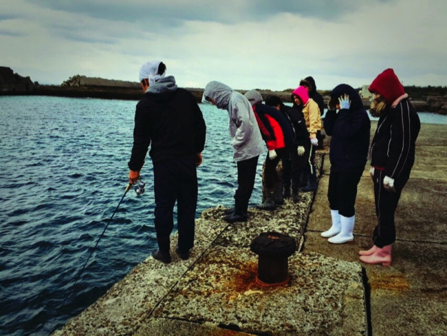 トカラ列島宝島の港で釣りを楽しむボランティア学生