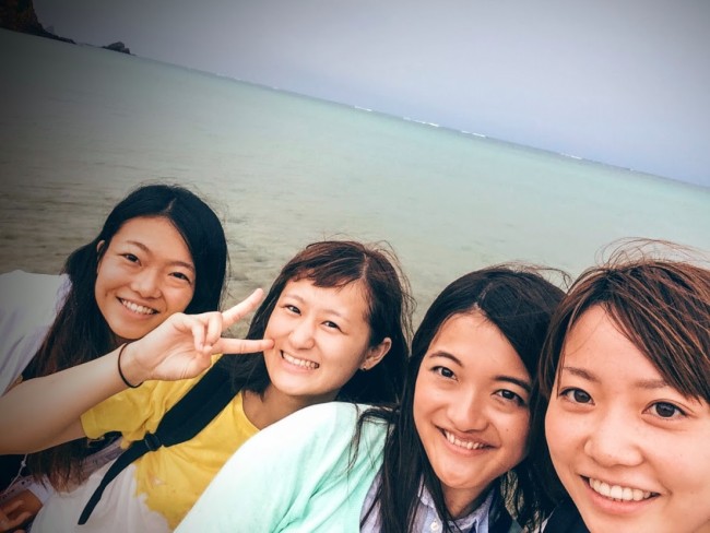 沖縄の美しい風景のなかを散策する学生ボランティア