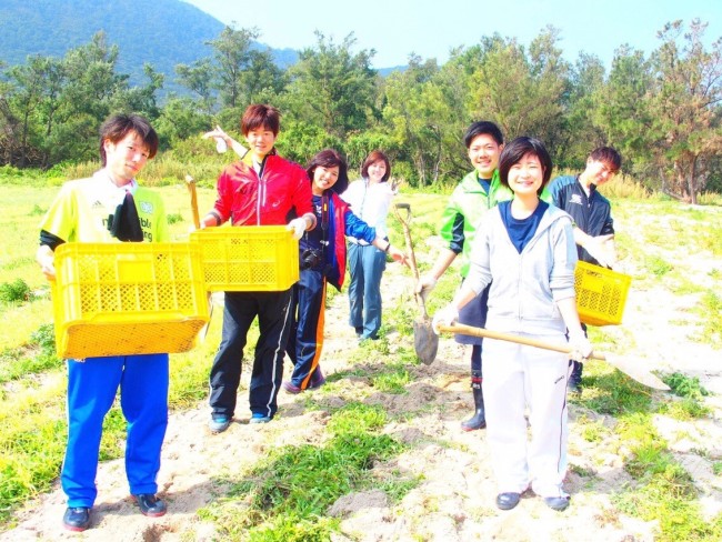 宝島で島らっきょうの収穫をする学生ボランティア