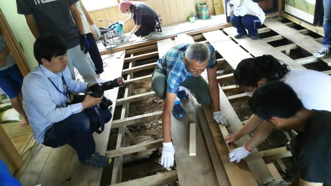 焼尻島で床張りボランティアをする学生