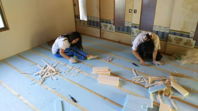 焼尻島で床貼りボランティアをする学生