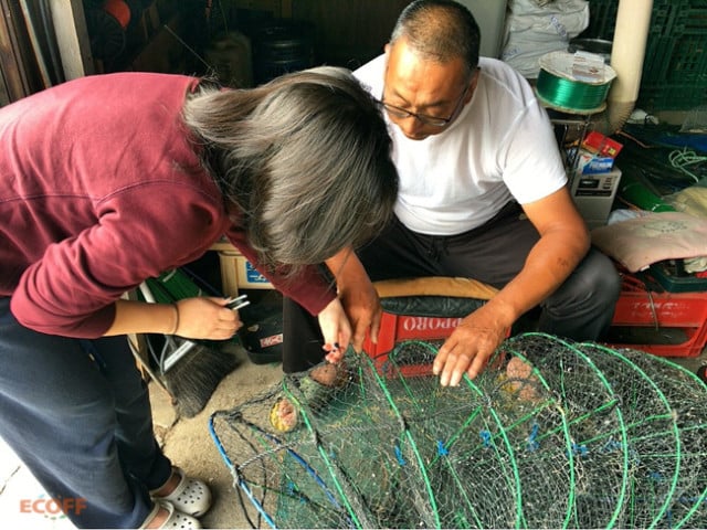 北海道焼尻島で漁師に作業を教わっているボランティア